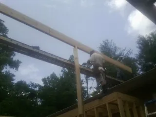 Carpenter setting a ridge beam over a new addition frame — Ice Dam Removal by Roofing Brothers in Prior Lake