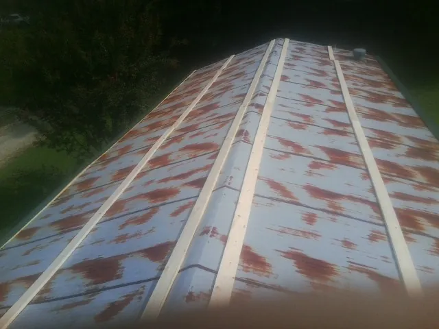 Rusted metal roof panels with new wood purlins before replacement — Storm Damage Roof Repair in Prior Lake by Roofing Brothers